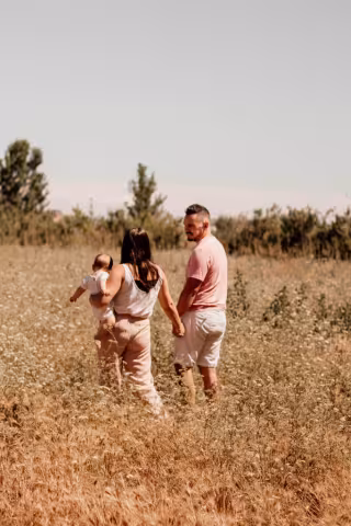 Pareja caminando por el campo con un niño